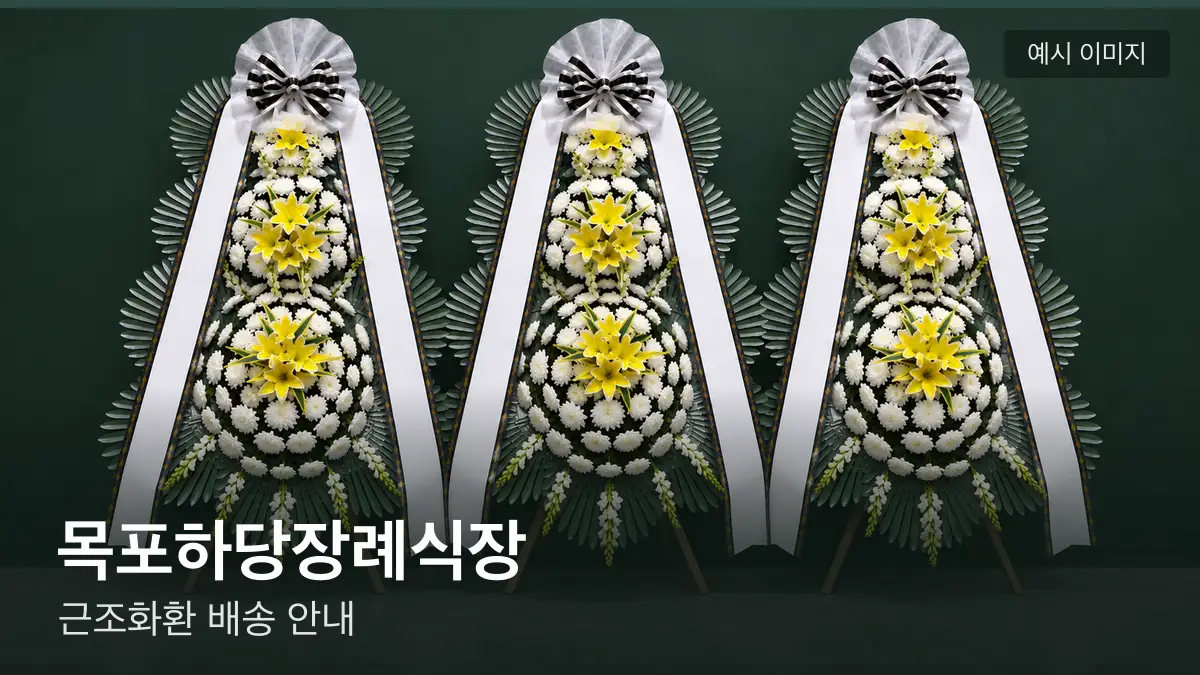 목포하당장례식장 근조화환 예시 이미지 — 흰 국화 3단 근조화환이 벽을 따라 나란히 놓인 모습