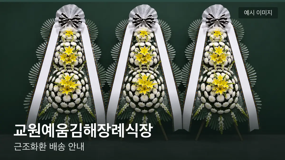 교원예움김해장례식장 근조화환 예시 이미지 — 흰 국화 3단 근조화환이 벽을 따라 나란히 놓인 모습