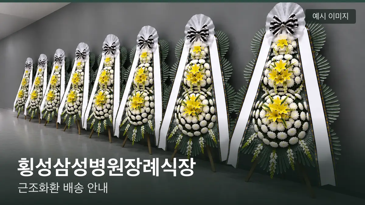 횡성삼성병원장례식장 근조화환 예시 이미지 — 흰 국화 3단 근조화환이 벽을 따라 나란히 놓인 모습