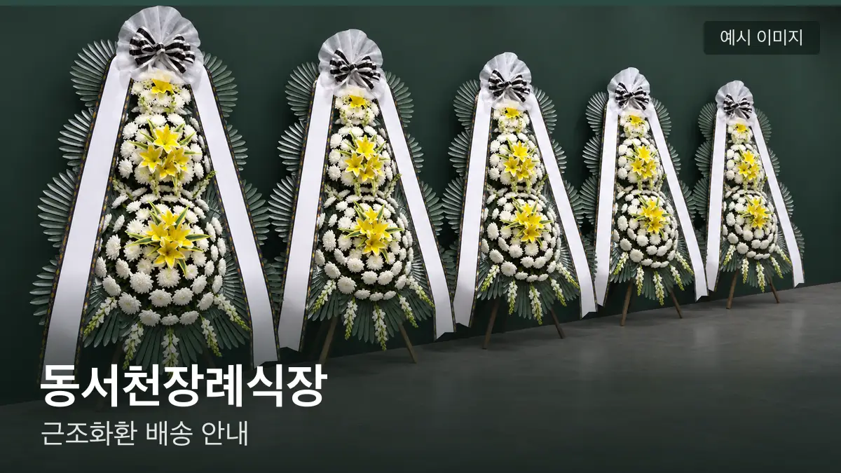 동서천장례식장 근조화환 예시 이미지 — 흰 국화 3단 근조화환이 벽을 따라 나란히 놓인 모습
