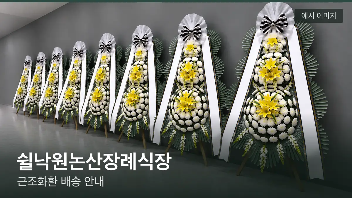 쉴낙원논산장례식장 근조화환 예시 이미지 — 흰 국화 3단 근조화환이 벽을 따라 나란히 놓인 모습