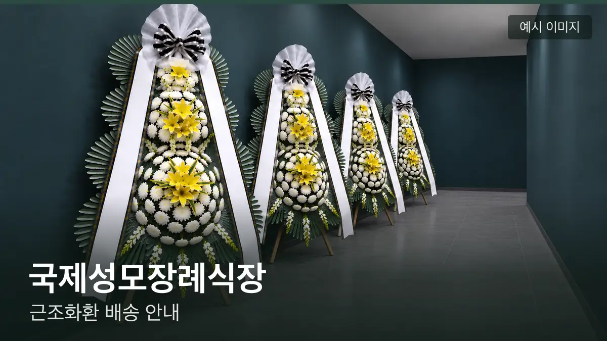 국제성모장례식장 근조화환 예시 이미지 — 흰 국화 3단 근조화환이 벽을 따라 나란히 놓인 모습