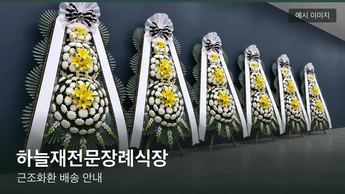 하늘재전문장례식장 근조화환 예시 이미지 — 흰 국화 3단 근조화환이 벽을 따라 나란히 놓인 모습