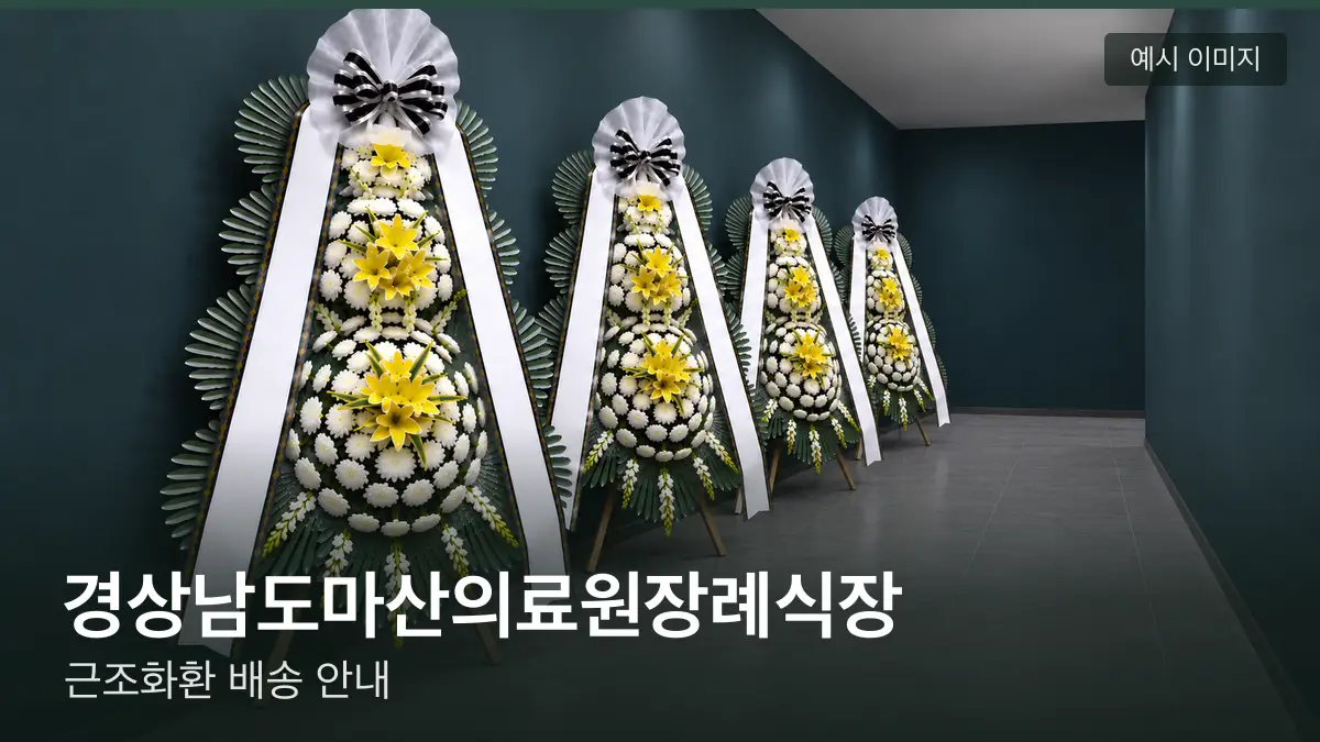 경상남도마산의료원장례식장 근조화환 예시 이미지 — 흰 국화 3단 근조화환이 벽을 따라 나란히 놓인 모습