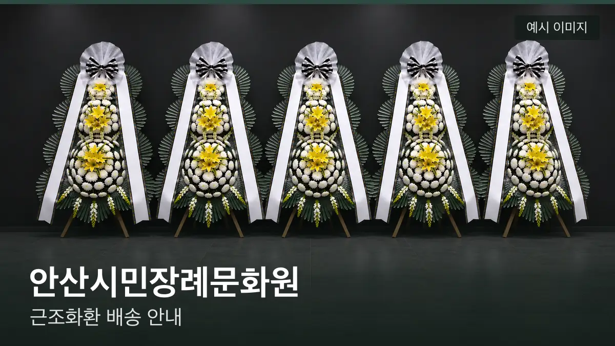 안산시민장례문화원 근조화환 예시 이미지 — 흰 국화 3단 근조화환이 벽을 따라 나란히 놓인 모습