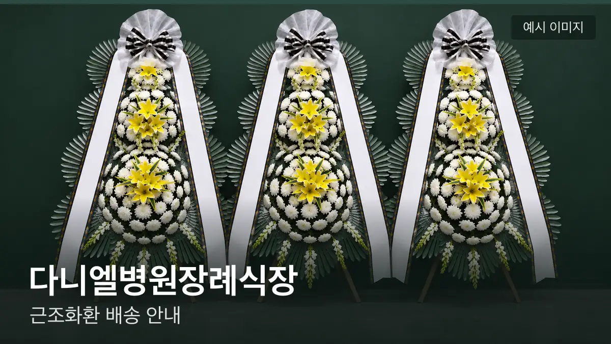 다니엘병원장례식장 근조화환 예시 이미지 — 흰 국화 3단 근조화환이 벽을 따라 나란히 놓인 모습