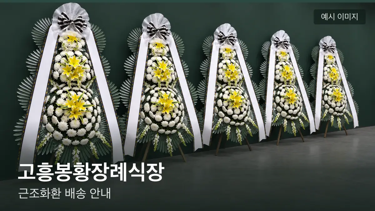 고흥봉황장례식장 근조화환 예시 이미지 — 흰 국화 3단 근조화환이 벽을 따라 나란히 놓인 모습