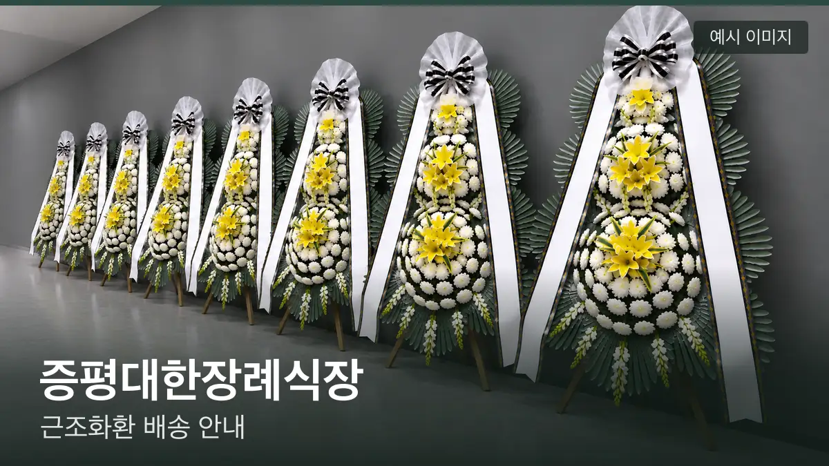 증평대한장례식장 근조화환 예시 이미지 — 흰 국화 3단 근조화환이 벽을 따라 나란히 놓인 모습