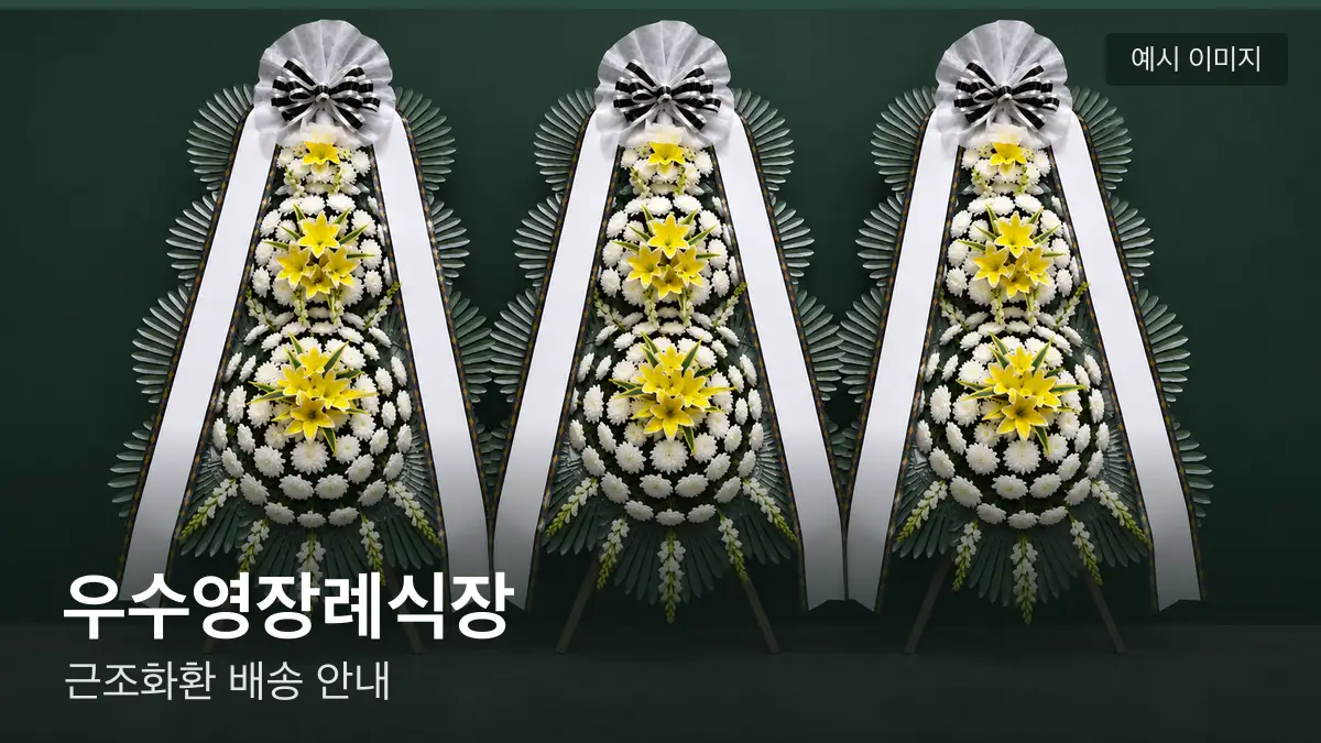 우수영장례식장 근조화환 예시 이미지 — 흰 국화 3단 근조화환이 벽을 따라 나란히 놓인 모습