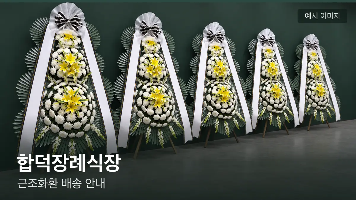합덕장례식장 근조화환 예시 이미지 — 흰 국화 3단 근조화환이 벽을 따라 나란히 놓인 모습