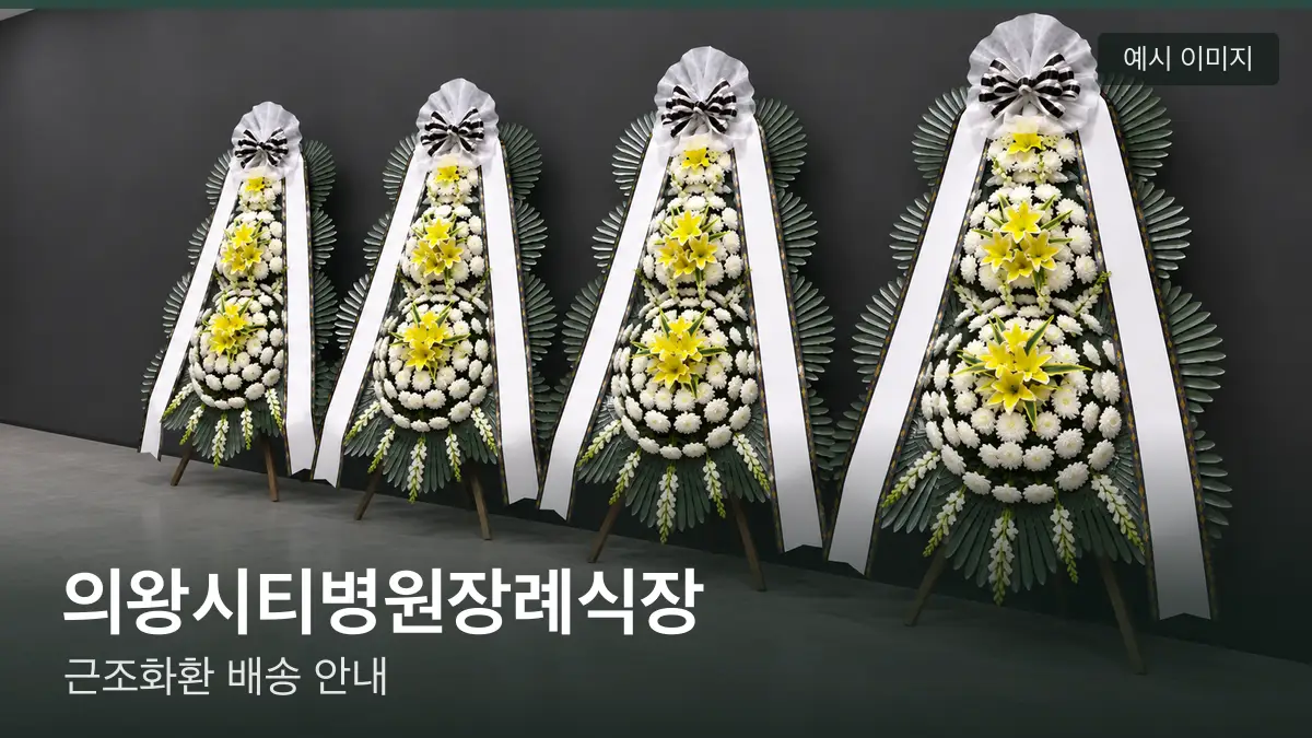 의왕시티병원장례식장 근조화환 예시 이미지 — 흰 국화 3단 근조화환이 벽을 따라 나란히 놓인 모습