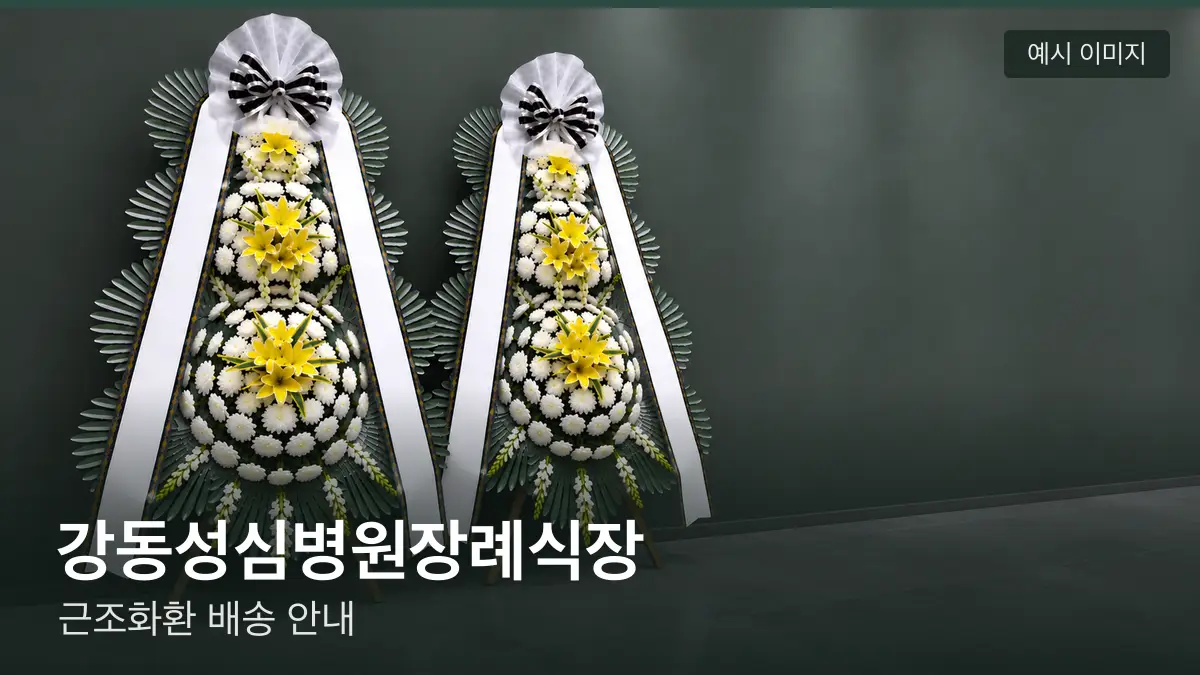 강동성심병원장례식장 근조화환 예시 이미지 — 흰 국화 3단 근조화환이 벽을 따라 나란히 놓인 모습