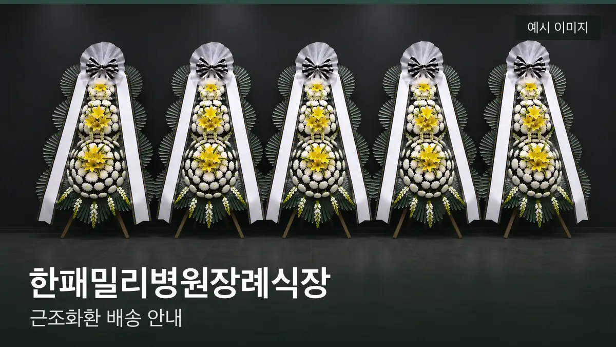 한패밀리병원장례식장 근조화환 예시 이미지 — 흰 국화 3단 근조화환이 벽을 따라 나란히 놓인 모습