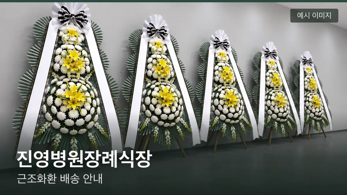 진영병원장례식장 근조화환 예시 이미지 — 흰 국화 3단 근조화환이 벽을 따라 나란히 놓인 모습