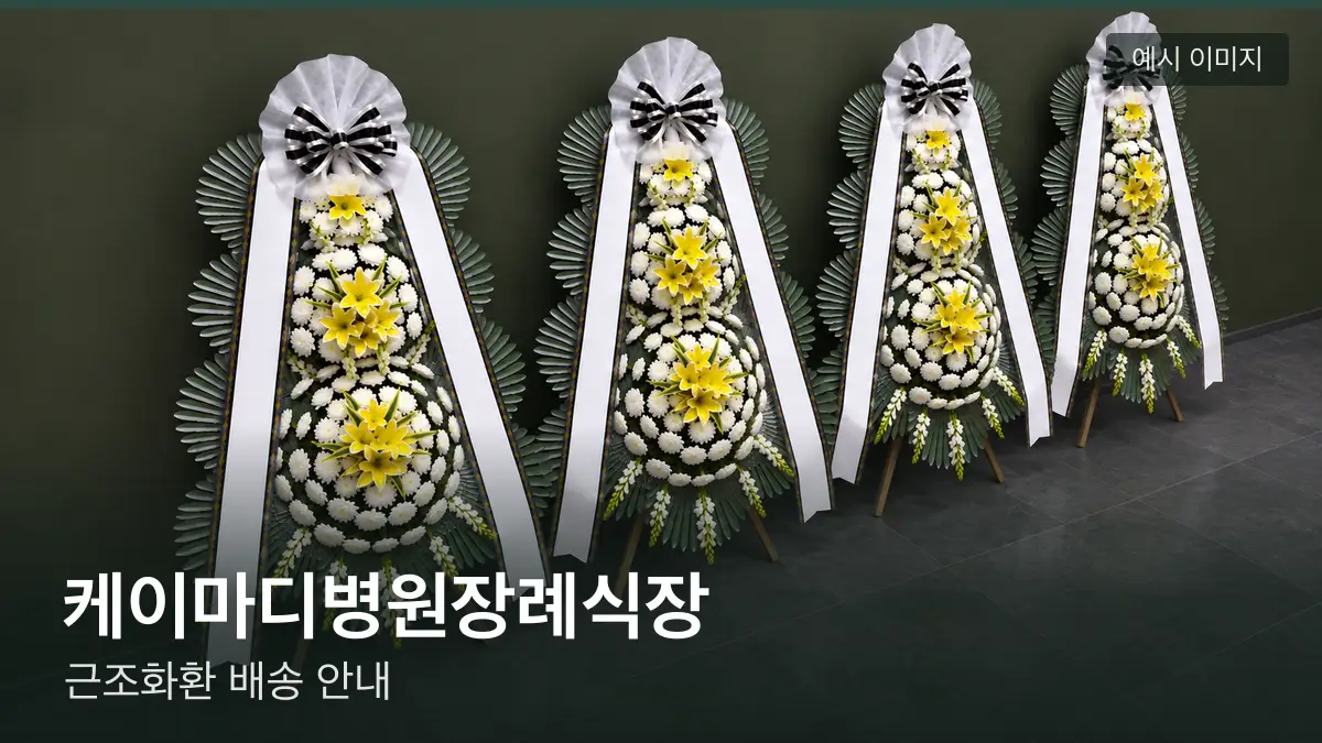 케이마디병원장례식장 근조화환 예시 이미지 — 흰 국화 3단 근조화환이 벽을 따라 나란히 놓인 모습