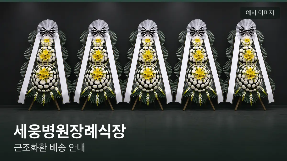 세웅병원장례식장 근조화환 예시 이미지 — 흰 국화 3단 근조화환이 벽을 따라 나란히 놓인 모습