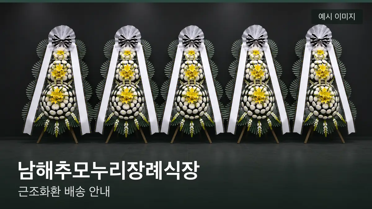 남해추모누리장례식장 근조화환 예시 이미지 — 흰 국화 3단 근조화환이 벽을 따라 나란히 놓인 모습