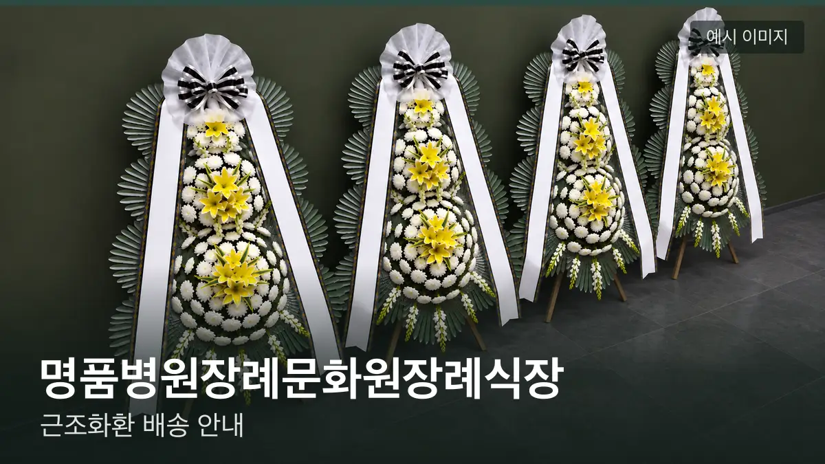 명품병원장례문화원장례식장 근조화환 예시 이미지 — 흰 국화 3단 근조화환이 벽을 따라 나란히 놓인 모습
