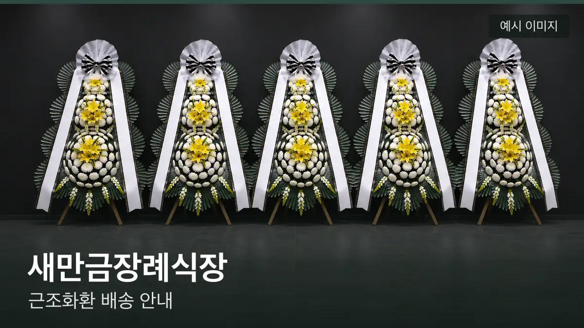 새만금장례식장 근조화환 예시 이미지 — 흰 국화 3단 근조화환이 벽을 따라 나란히 놓인 모습