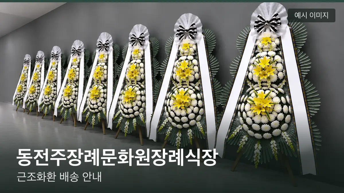 동전주장례문화원장례식장 근조화환 예시 이미지 — 흰 국화 3단 근조화환이 벽을 따라 나란히 놓인 모습