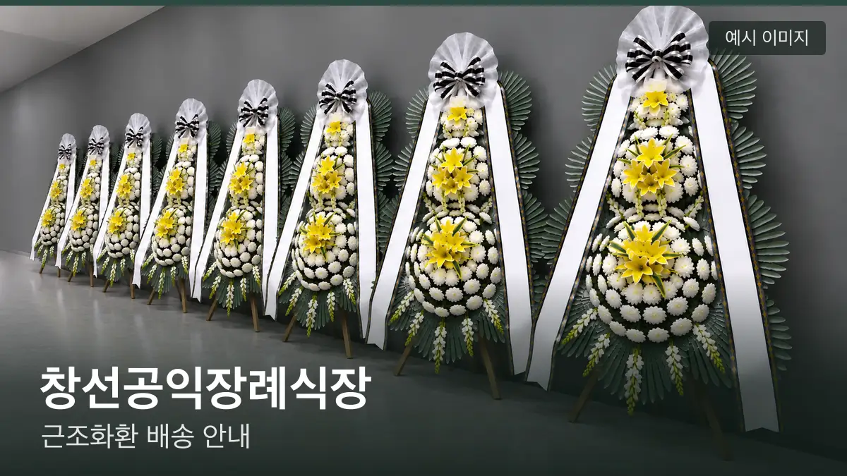 창선공익장례식장 근조화환 예시 이미지 — 흰 국화 3단 근조화환이 벽을 따라 나란히 놓인 모습