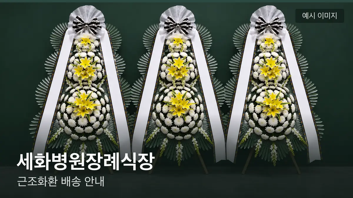 세화병원장례식장 근조화환 예시 이미지 — 흰 국화 3단 근조화환이 벽을 따라 나란히 놓인 모습