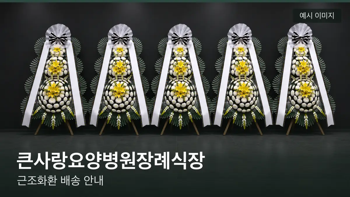 큰사랑요양병원장례식장 근조화환 예시 이미지 — 흰 국화 3단 근조화환이 벽을 따라 나란히 놓인 모습