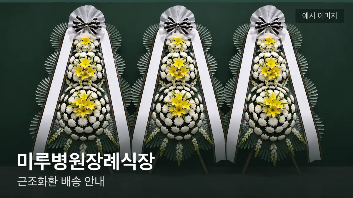 미루병원장례식장 근조화환 예시 이미지 — 흰 국화 3단 근조화환이 벽을 따라 나란히 놓인 모습