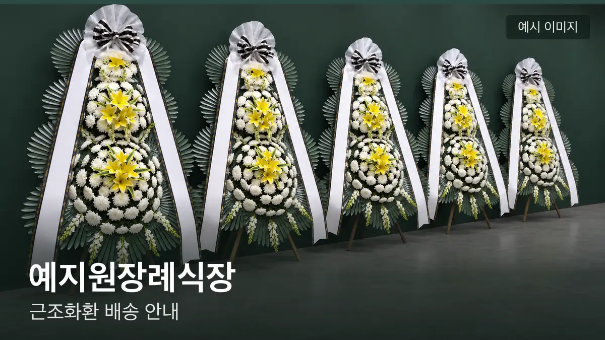 예지원장례식장 근조화환 예시 이미지 — 흰 국화 3단 근조화환이 벽을 따라 나란히 놓인 모습