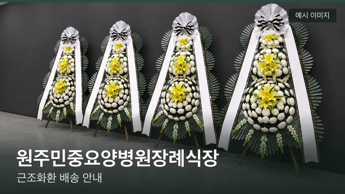 원주민중요양병원장례식장 근조화환 예시 이미지 — 흰 국화 3단 근조화환이 벽을 따라 나란히 놓인 모습