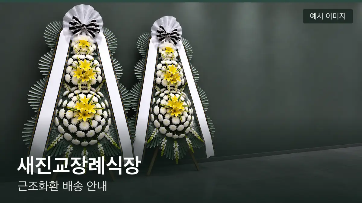 새진교장례식장 근조화환 예시 이미지 — 흰 국화 3단 근조화환이 벽을 따라 나란히 놓인 모습