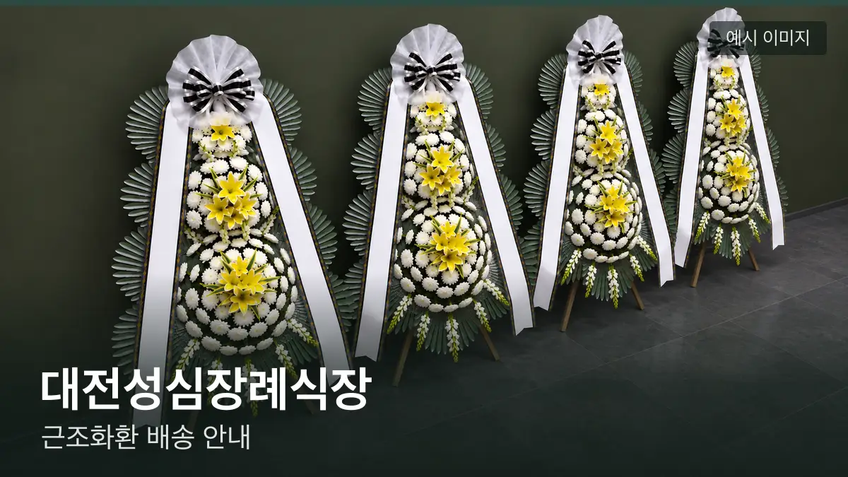 대전성심장례식장 근조화환 예시 이미지 — 흰 국화 3단 근조화환이 벽을 따라 나란히 놓인 모습